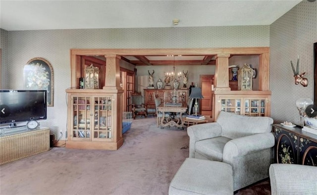 living room featuring decorative columns, carpet flooring, and a chandelier