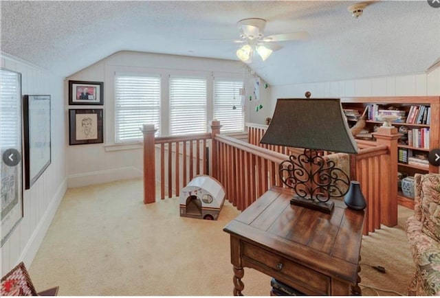 carpeted office space featuring ceiling fan, a textured ceiling, and vaulted ceiling