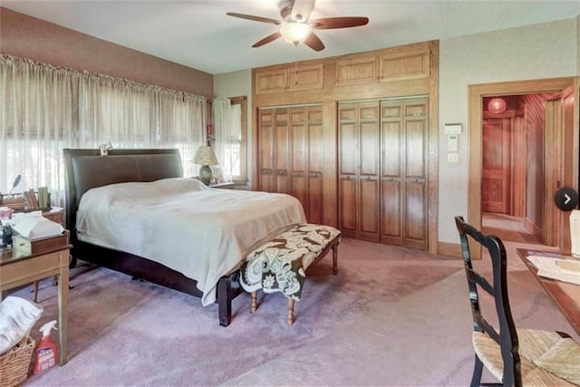 bedroom featuring light carpet, multiple windows, and ceiling fan