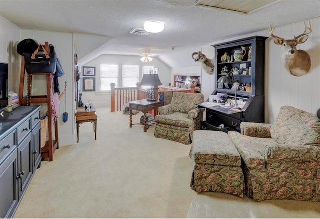 sitting room with lofted ceiling, a textured ceiling, light colored carpet, and ceiling fan