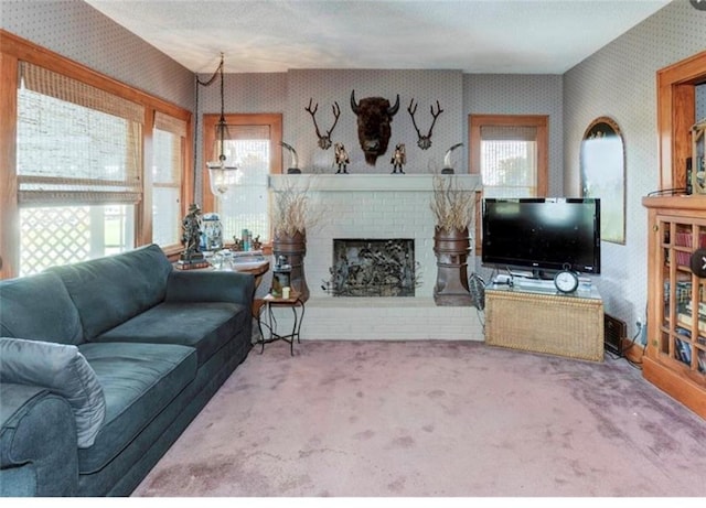 living room with a brick fireplace, carpet floors, and a healthy amount of sunlight