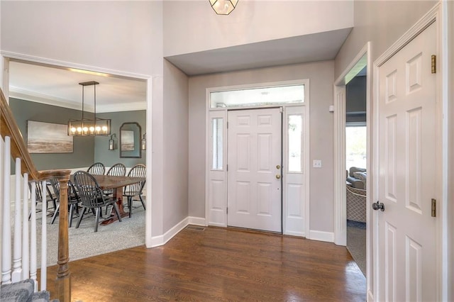 entrance foyer featuring ornamental molding and dark wood-type flooring