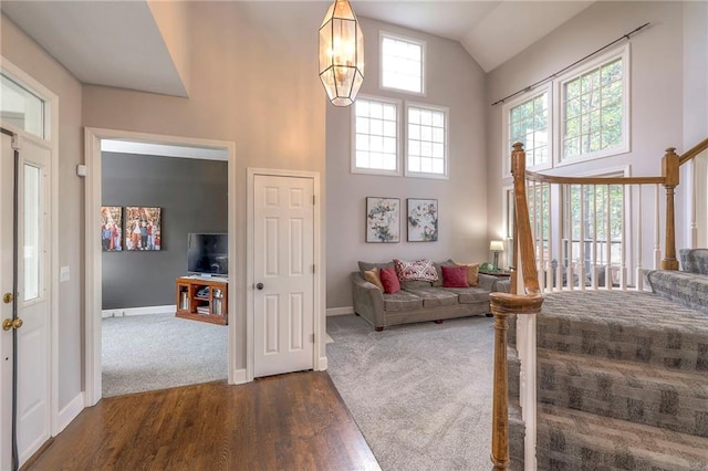 bedroom with dark wood-type flooring, high vaulted ceiling, and an inviting chandelier