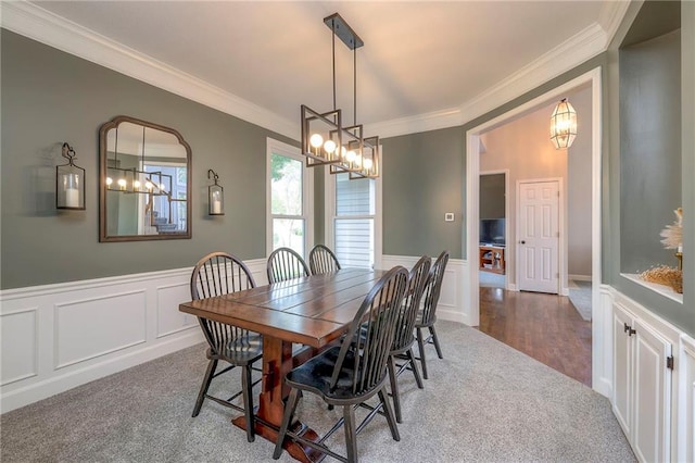 carpeted dining room featuring ornamental molding