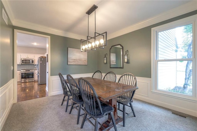 dining room with dark hardwood / wood-style flooring, a notable chandelier, ornamental molding, and a wealth of natural light