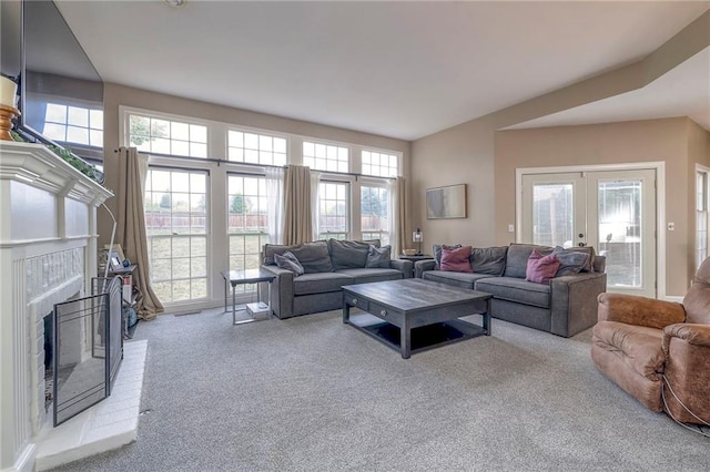 living room with french doors, a healthy amount of sunlight, a fireplace, and light colored carpet