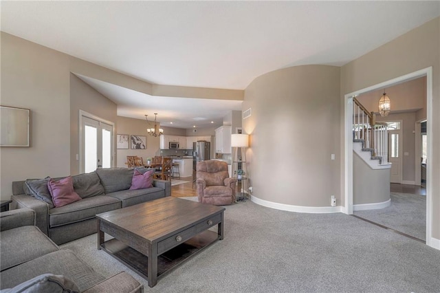 living room with light carpet and a chandelier