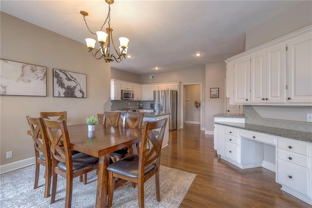 dining room with a notable chandelier and dark hardwood / wood-style floors