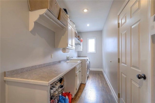 laundry area featuring cabinets, independent washer and dryer, and hardwood / wood-style floors