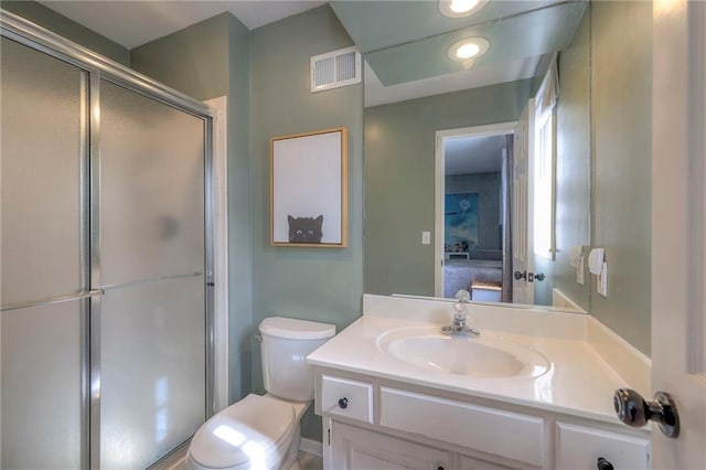 bathroom featuring vanity, toilet, and an enclosed shower