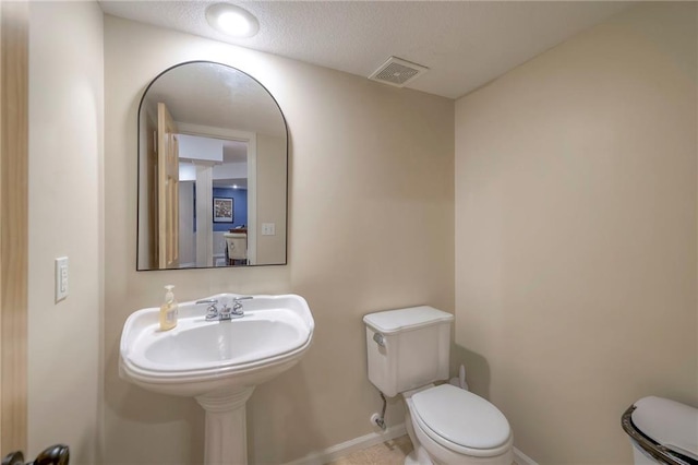 bathroom featuring toilet and a textured ceiling