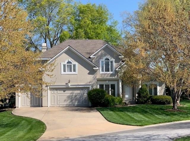 view of front of property featuring a front lawn and a garage