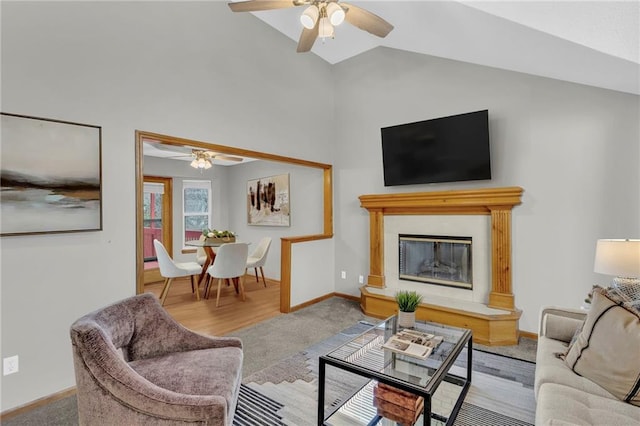 carpeted living room with ceiling fan and lofted ceiling