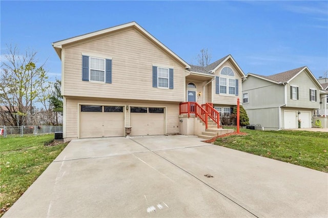 raised ranch featuring central AC, a garage, and a front lawn