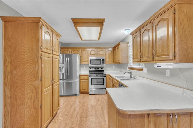 kitchen featuring sink, kitchen peninsula, stainless steel appliances, and light hardwood / wood-style flooring