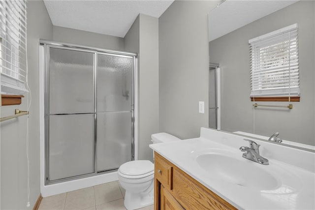 bathroom with tile patterned floors, a textured ceiling, vanity, a shower with door, and toilet