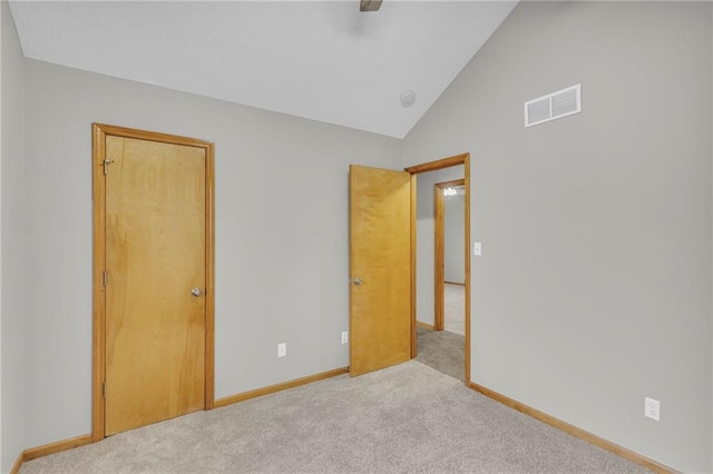 unfurnished bedroom featuring light carpet and vaulted ceiling