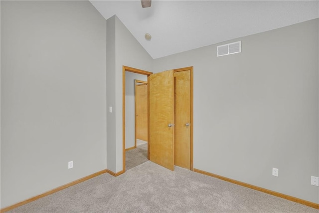 spare room featuring lofted ceiling and light carpet