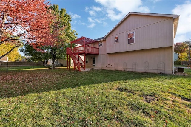 back of house with a lawn, central AC unit, and a deck