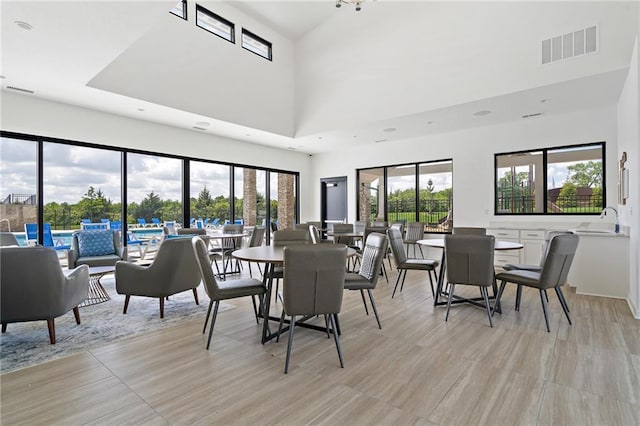 dining room featuring a high ceiling, sink, and plenty of natural light