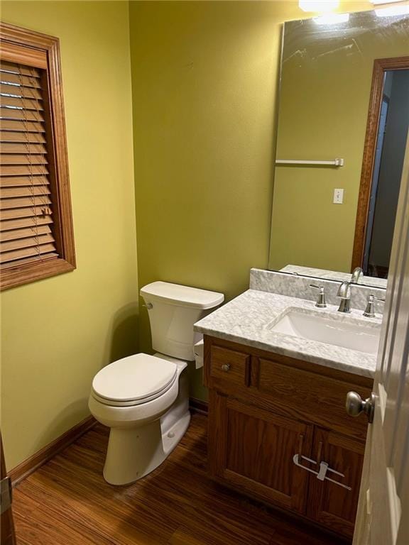 bathroom with hardwood / wood-style flooring, vanity, and toilet