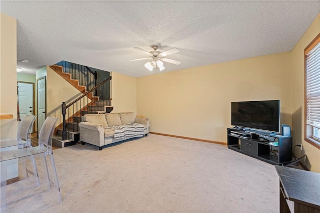 carpeted living room featuring a textured ceiling and ceiling fan