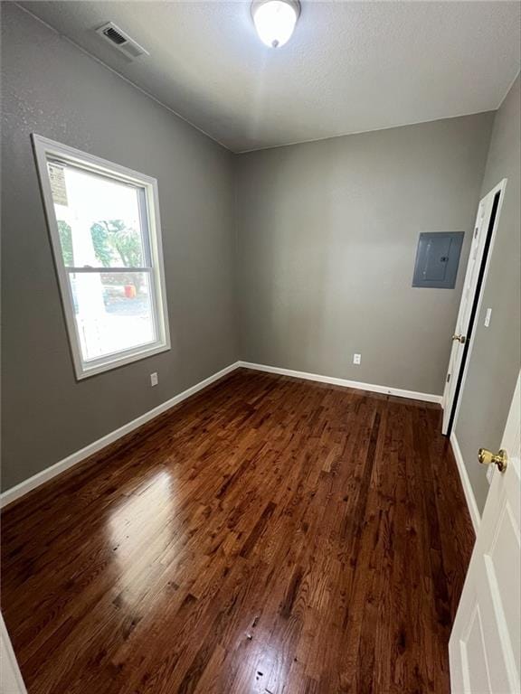 601 W 5th St, Pittsburg, KS 66762 - empty room with dark wood-style flooring, baseboards, and electric panel