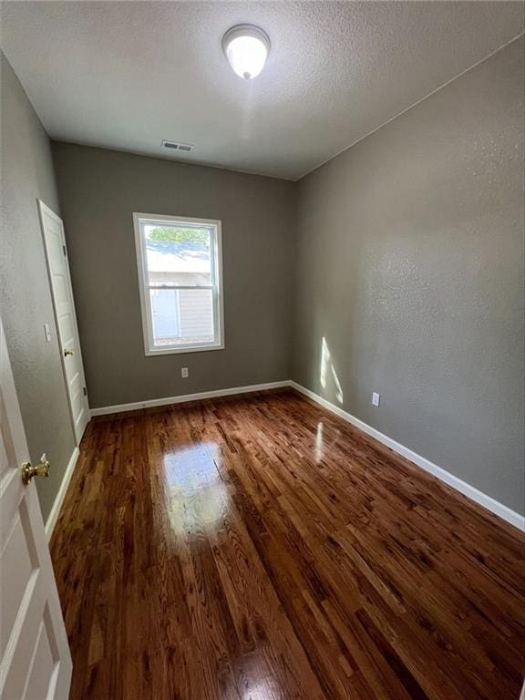 empty room with dark wood-type flooring