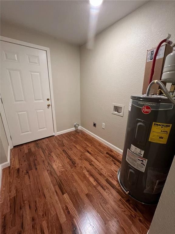 laundry room with washer hookup, electric water heater, and dark wood-type flooring