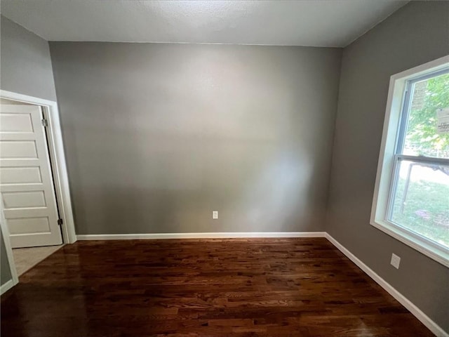 unfurnished room with dark wood-type flooring