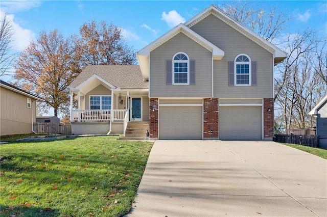 split level home with a porch, a garage, and a front lawn