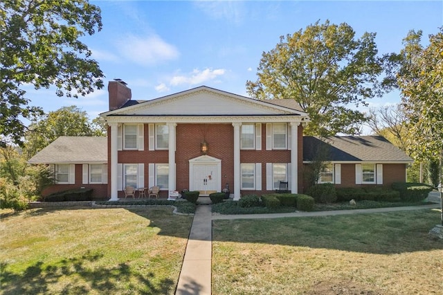 greek revival inspired property featuring a front yard