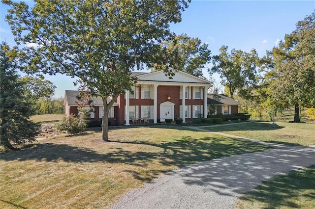 greek revival inspired property featuring a front lawn