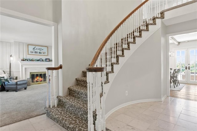 stairs featuring french doors and carpet