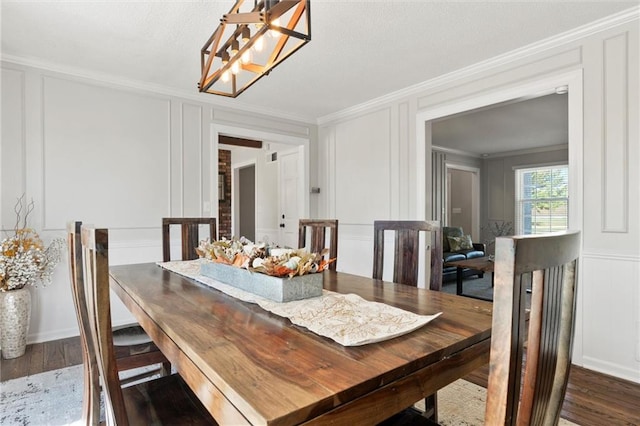 dining space featuring ornamental molding, a notable chandelier, and dark hardwood / wood-style floors