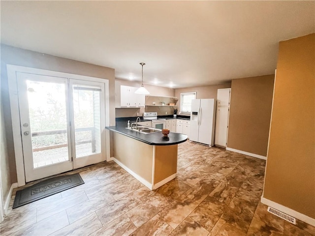 kitchen with white appliances, sink, kitchen peninsula, hanging light fixtures, and white cabinets