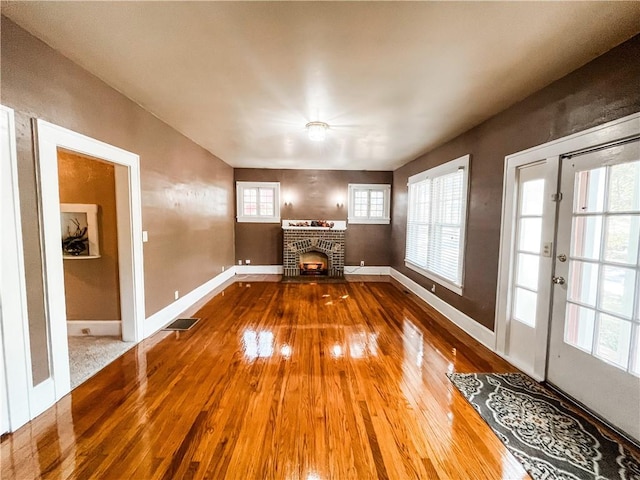 unfurnished living room featuring a fireplace and hardwood / wood-style flooring