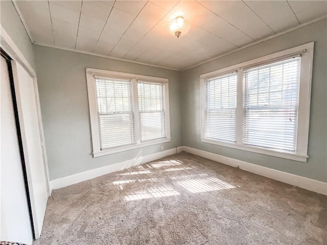 interior space featuring crown molding, a healthy amount of sunlight, and light colored carpet