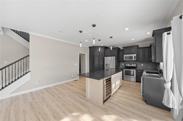 kitchen with backsplash, appliances with stainless steel finishes, a kitchen island, ornamental molding, and decorative light fixtures