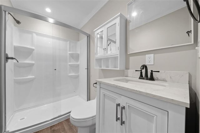 bathroom with wood-type flooring, toilet, walk in shower, vanity, and crown molding