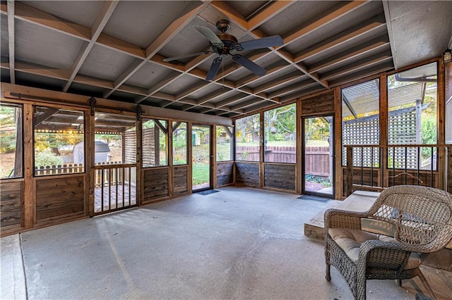 unfurnished sunroom featuring lofted ceiling, a healthy amount of sunlight, and ceiling fan