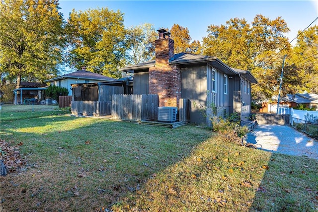 view of property exterior featuring a lawn and central AC