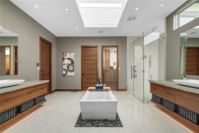 bathroom featuring tile patterned flooring, shower with separate bathtub, vanity, and a skylight