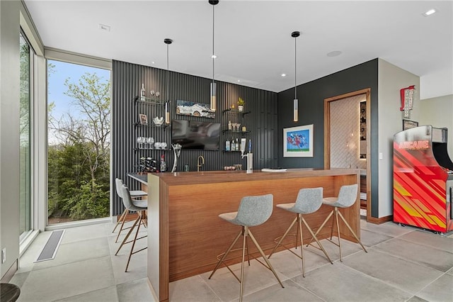 bar featuring decorative light fixtures and floor to ceiling windows