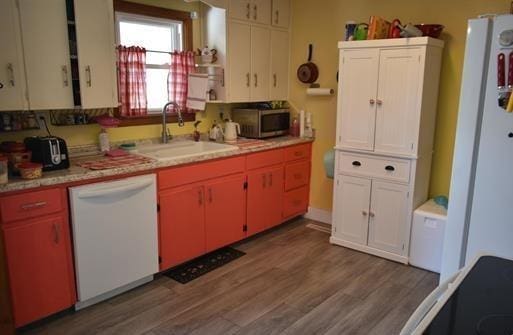 kitchen with dark hardwood / wood-style floors, sink, and white appliances