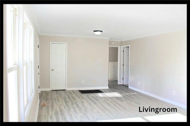 spare room with ornamental molding, plenty of natural light, and light hardwood / wood-style floors