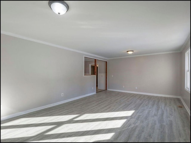 empty room featuring crown molding and light hardwood / wood-style floors