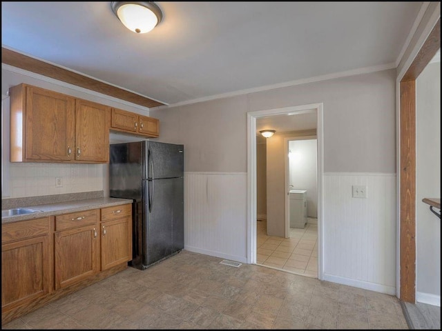 kitchen featuring black refrigerator and crown molding