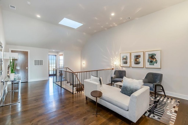 sitting room featuring lofted ceiling with skylight and dark wood-type flooring