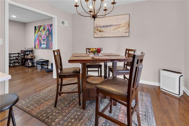 dining space with dark hardwood / wood-style flooring and a notable chandelier